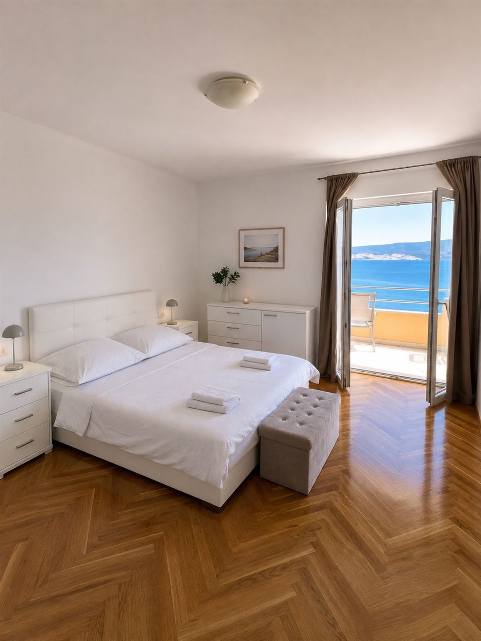 Bedroom with double bed and balcony door with sea view