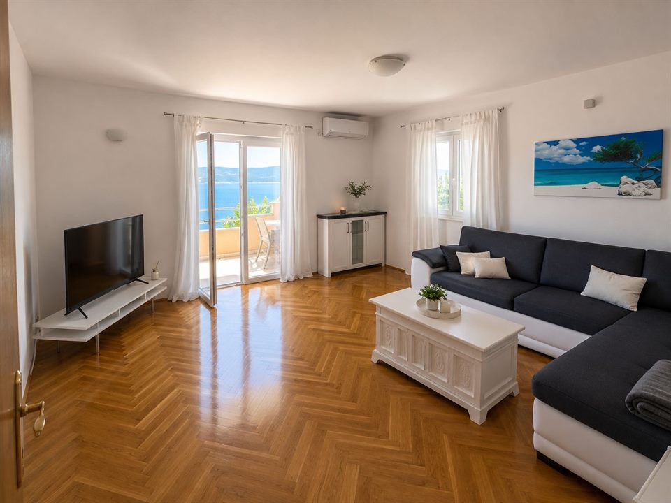 Living room with sofa, TV and access to the terrace
