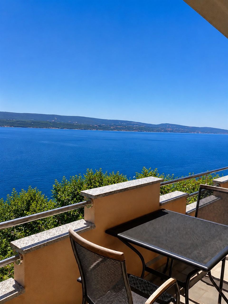 Terrace with table and chairs overlooking the sea and the island of Brač