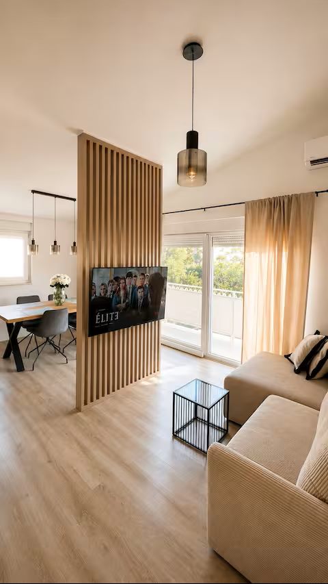 Living area with sofa, TV and wooden slat partition